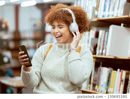Black woman, phone and music in library with headphones, streaming and laugh for meme on web app. University student, funny blog or social media with smile, smartphone and learning for education goal 130695380