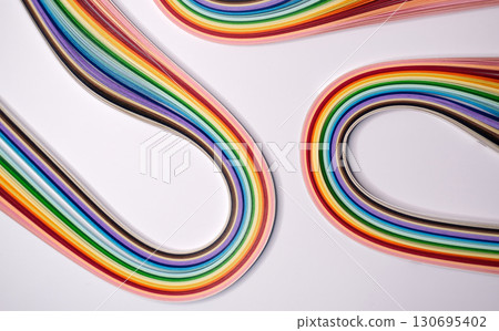A creative flat lay showcasing a collection of colorful paper quilling strips arranged into abstract, curving shapes on a white background A creative flat lay showcasing a collection of colorful paper quilling strips arranged into abstract, curving shapes on a white background 130695402