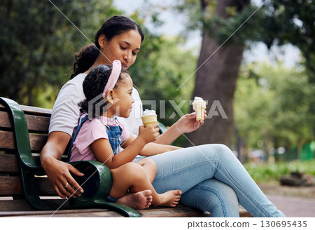 Summer, garden and ice cream with a mother and daughter bonding together while sitting on a bench outdoor in nature. Black family, children and park with a woman and girl enjoying a sweet snack 130695435