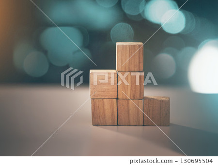 Building, business and blocks for investment, finance and growth on a table. Accounting, education and conceptual structure for profit, planning and investing in steps for progress on a desk 130695504