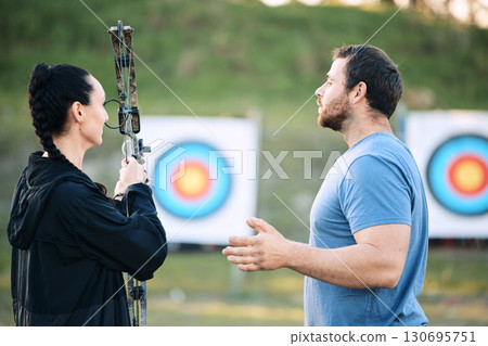 Sports, archery coach or bow and arrow learning for archer competition, athlete challenge or girl training practice. Teacher, teaching talk or man coaching woman on precision, aim and target shooting Sports, archery coach or bow and arrow learning for archer competition, athlete challenge or girl training practice. Teacher, teaching talk or man coaching woman on precision, aim and target shooting 130695751
