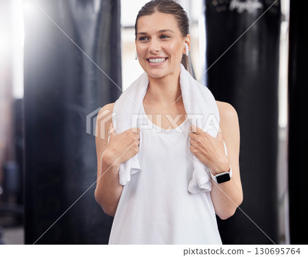 Woman, fitness and smile with towel in gym after workout, sweating and training. Happy sports female thinking of wellness in exercise club for health, performance and happiness with music earphones 130695764