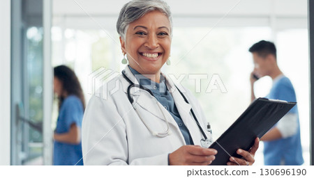 Senior woman, portrait smile and doctor in healthcare, career ambition or documents at hospital. Happy mature female person, medical professional or manager with clipboard in leadership at clinic 130696190