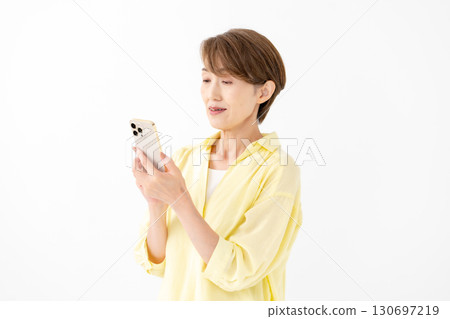 A woman operating a smartphone with a smile 130697219