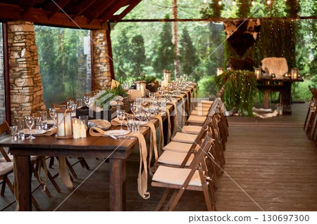 A large terrace for a wedding and banquet in a rustic style. Thrones and skins. Stylized as Vikings. Dark wood. A lot of greenery. 130697300