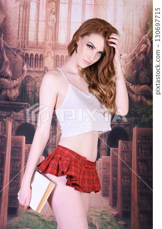 Tall, attractive, redhead model dressed as a schoolgirl in a fantasy library Tall, attractive, redhead model dressed as a schoolgirl in a fantasy library 130697715