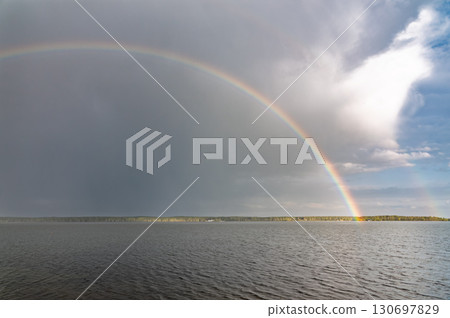 Rainbow over Blue lake with cloudy sky Rainbow over Blue lake with cloudy sky 130697829