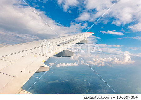 View from the airplane window at a beautiful cloudy sky and the airplane wing 130697864