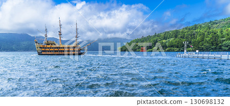 Panoramic view of Lake Ashi in summer: The Hakone Pirate Ship sailing on the lake [Hakone Town, Kanagawa Prefecture] 130698132