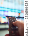 Watching television with remote control 130699426