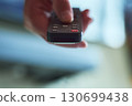 Hand holding a remote control 130699438