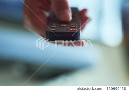 Hand holding a remote control Hand holding a remote control 130699438
