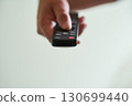 Hand holding a television remote control 130699440