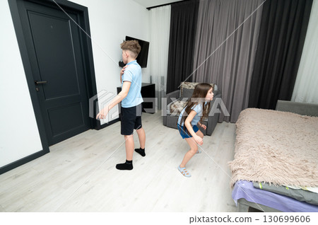 Children exploring a modern bedroom with curiosity and excitement during a playful afternoon adventure in a cozy home environment Children exploring a modern bedroom with curiosity and excitement during a playful afternoon adventure in a cozy home environment 130699606