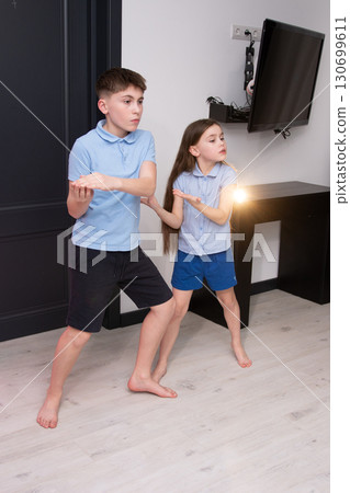 Children engaged in an imaginative game in a cozy living room while showcasing creativity and playfulness during a delightful afternoon at home 130699611