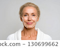 Face lifting. The face of an elderly beautiful woman with relief arrows and massage lines on a white background. Advertising of anti-aging skin care 130699662