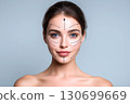 Beautiful woman showing facial plastic surgery areas lifting arrows 130699669