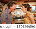 married couple is quarreling in the kitchen. Husband and wife are screaming in home. Family conflict and disagreements 130699690