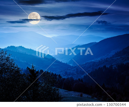 beautiful afternoon in carpathian mountains at night. scenic autumn weather. forest in colorful foliage. distant valley in haze and full moon light beautiful afternoon in carpathian mountains at night. scenic autumn weather. forest in colorful foliage. distant valley in haze and full moon light 130700344