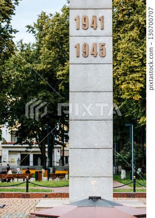 Eternal flame at the memorial with burning flame against the background of the city square. Inscription 1941-1945. 130700707