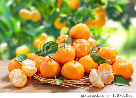 fresh mandarin oranges fruit or tangerines with leaves on wooden table on garden background 130701082
