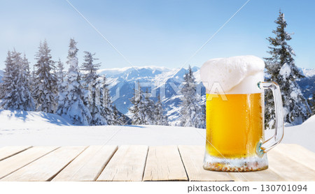 mug of beer on old wooden table against winter landscape 130701094