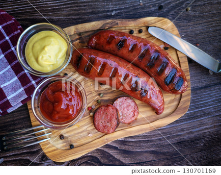 Delicious grilled sausages  on wooden  board 130701169
