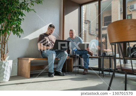 Two skilled professionals devops engaged in collaborative efforts within a contemporary workspace Two skilled professionals devops engaged in collaborative efforts within a contemporary workspace 130701570