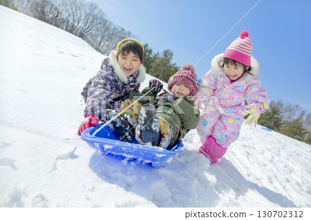Children playing in the snow in the winter park 130702312