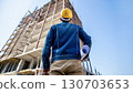 Construction worker overseeing project with helmet view Construction worker overseeing project with helmet view 130703653