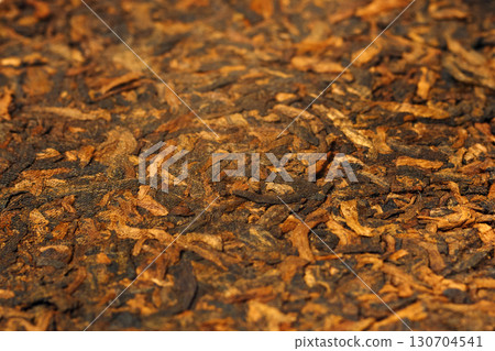 Close-up view of a puer tea cake reveals its intricate texture and rich color. 130704541