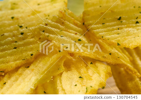 Crispy flavorful chips stacked high in a bowl against, extreme close-up Crispy flavorful chips stacked high in a bowl against, extreme close-up 130704545