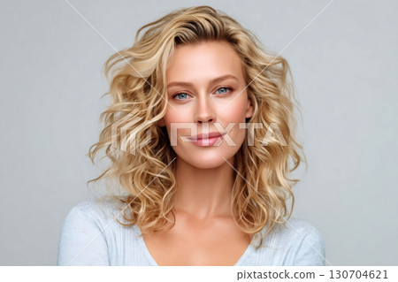 Beautiful blonde woman smiling with perfect curly hair and skin 130704621