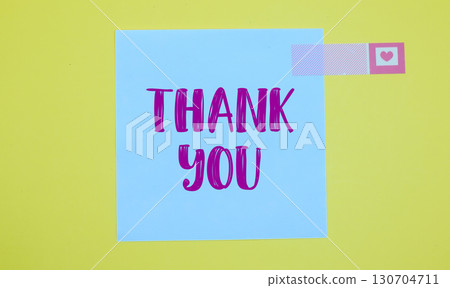 Thank you text on white sticky note on yellow background 130704711