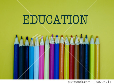 EDUCATION word on yellow background with colorful pencils 130704715