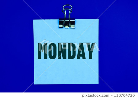 MONDAY word on a white sticky note on blue background 130704720