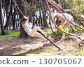little girl with her mom climbing tree in green park, lifestyle people concept 130705067