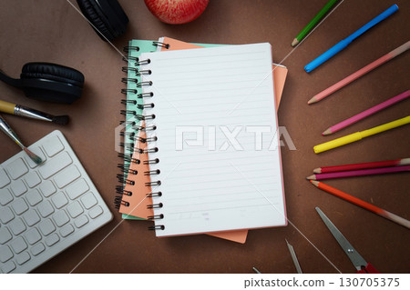 Creative Workspace: Notebooks, Colored Pencils, and Apple for Inspiration 130705375
