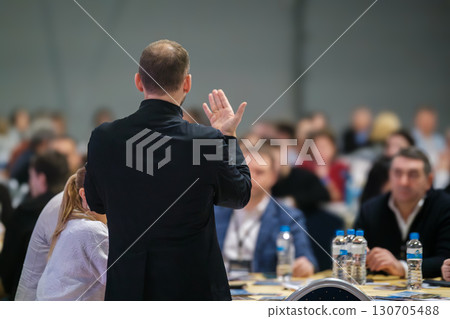 Back view of presenter addressing audience in conference room 130705488