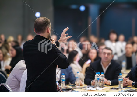 Speaker addressing audience at professional conference in modern event setting 130705489