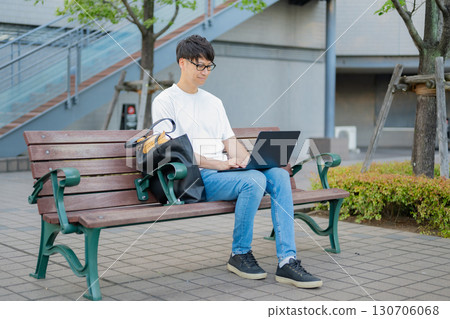 一名男子在長椅上操作電腦 130706068