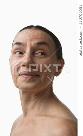 Senior woman turning head with slight smile in skincare portrait Senior woman turning head with slight smile in skincare portrait 130706583