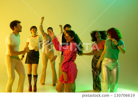 Group of stylish friends dancing together in neon yellow atmosphere Group of stylish friends dancing together in neon yellow atmosphere 130706619