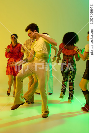 Man in yellow shirt dancing confidently in retro party group 130706648