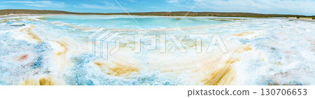 Salt lake with white mineral crystals and turquoise water against hills and sky Salt lake with white mineral crystals and turquoise water against hills and sky 130706653