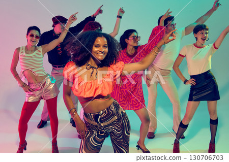 Woman in red crop top leading group dance with smiles and retro style 130706703
