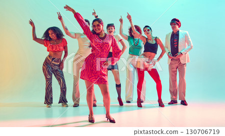 Smiling woman leading dance group with confidence in vibrant studio 130706719