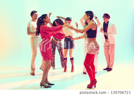 Stylish friends dancing together in retro themed group celebration Stylish friends dancing together in retro themed group celebration 130706721