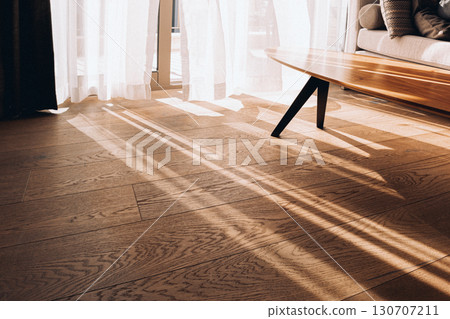 Modern room interior with an open window in minimal style. Transparent tulle with morning sun rays on shadow background. High quality photo 130707211