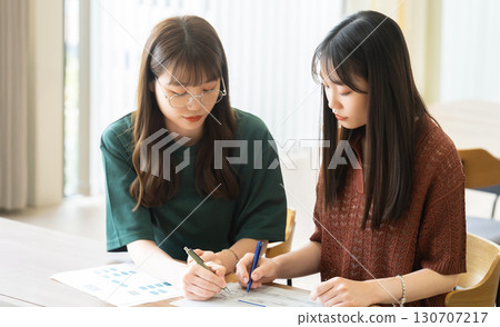 Two women/businesswomen thinking while using a computer 130707217